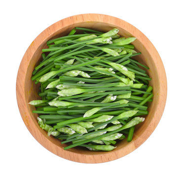 Top view of slice green onions in wooden bowl on white