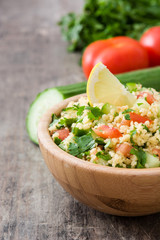 Tabbouleh salad with couscous on rustic wooden table

