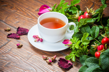 Healthy tea with a dogrose on wooden table