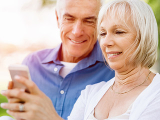 Happy senior couple looking at smartphone