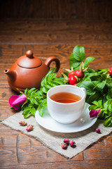 Healthy tea with a dogrose on wooden table