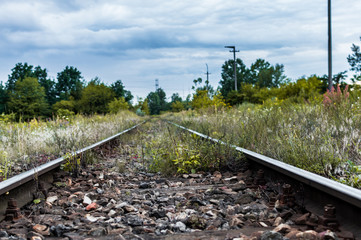 Old railway tracks and gravel leading into the infinite distance with selective focus