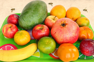 Assorted fruit on a green tray and honey bees flying around. Colorful sweet aromatic fruits for raw eating or squeezing or preparing smoothie. Image done with old paper textured background