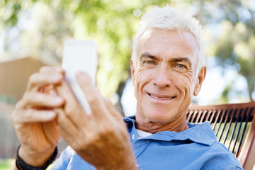 Obraz premium LoMature man outdoors using mobile phone