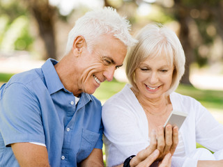 Happy senior couple looking at smartphone