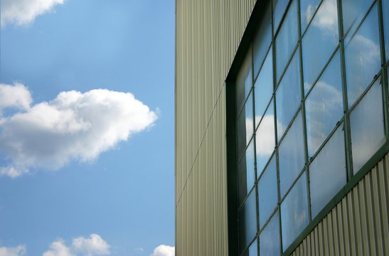 Reflektion fr&aring;n en bl&aring; himmel i ett gammalt lagerf&ouml;nster. En reflektion fr&aring;n en svunnen tid d&aring; huset &auml;r rivet. Gammalt tekohus. 