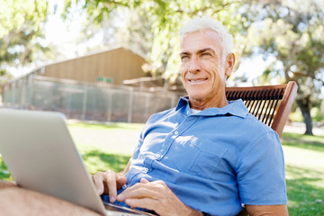 Obraz premium Senior man with notebook sitting in the park