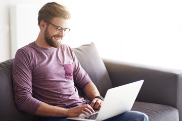 Handsome man using laptop at home