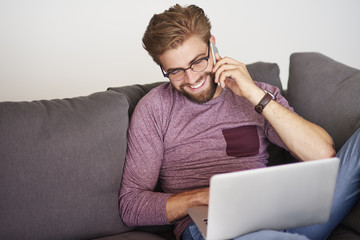 Laughing man using modern devices