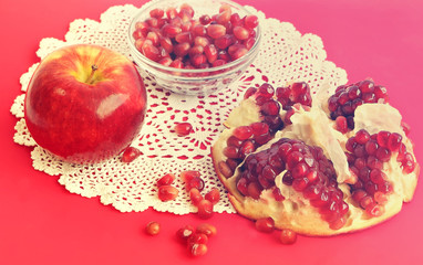 Red apple and pomegranate fruits on the red