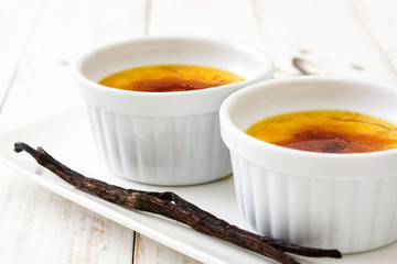 Traditional French creme brulee dessert with caramelized sugar on top, on wooden table

