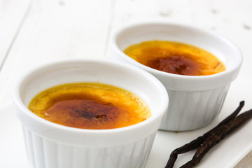 Traditional French creme brulee dessert with caramelized sugar on top, on wooden table

