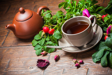 Healthy tea with a dogrose on wooden table