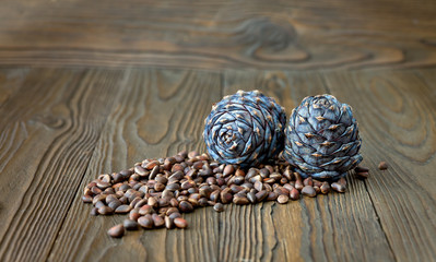 Cedar cones and nuts on a brown wooden background