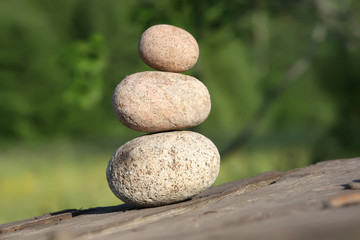 Fototapeta na wymiar Three stones on a wooden table