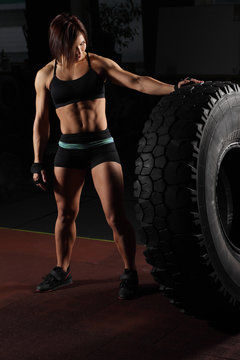 Fit female athlete performing a tire flip