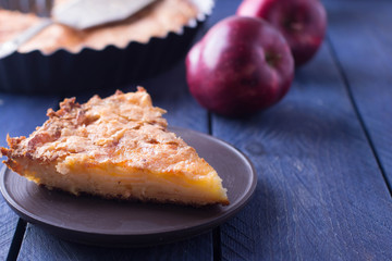 Slice of homemade apple pie on a wooden background. Autumn fruit pie