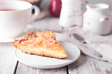 Slice of homemade apple pie on a wooden background. Autumn breakfast with fruit pie and tea.