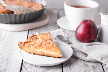 Slice of homemade apple pie on a wooden background. Autumn breakfast with fruit pie and tea.