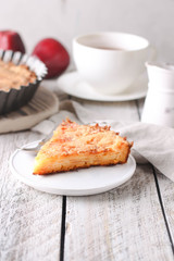 Slice of homemade apple pie on a wooden background. Autumn breakfast with fruit pie and tea.