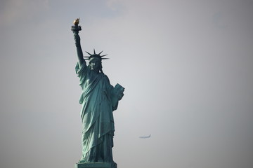 Obraz na płótnie Canvas Statue of Liberty with Plane landing