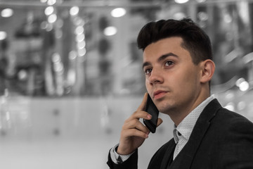 Concerned young businessman making a call by an escalator