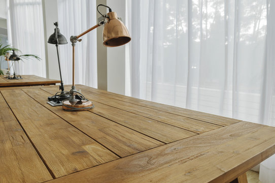 wooden desk with lamp near the window