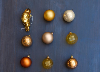 Christmas golden decorations on dark wooden background, top view