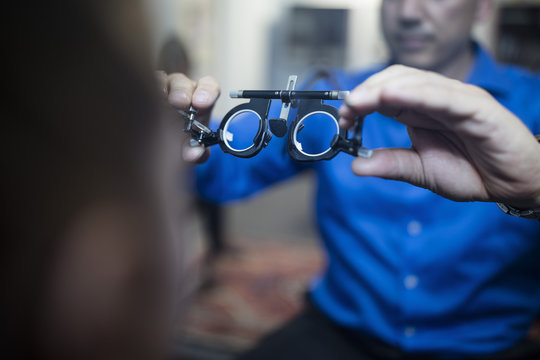 Optometrist holding test frames for girl