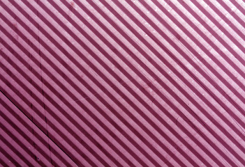Pink metal plate surface with scratches.