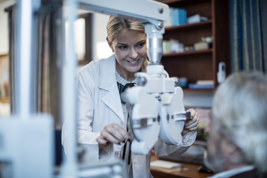 Female optometrist doing eye test with patient