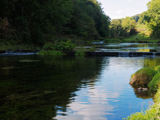 River Lathkill flowing over small weirs in Lathkill Dale, Derbyshire