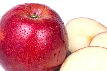 one big red apple close with three rifled pieces