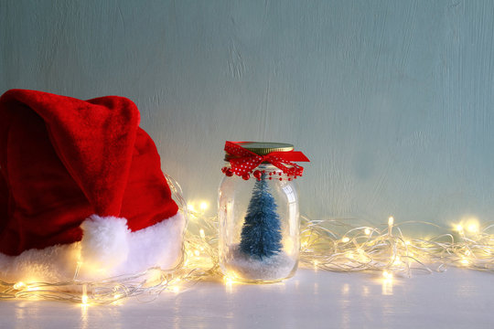 christmas tree in mason jar with garland lights next to santa ha