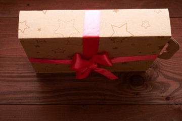 gift wrap with a pink ribbon on a wooden table