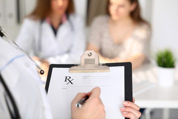 Obraz na płótnie Canvas Close-up of a female doctor while filling up medical prescription