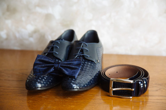 Groom accessories, bow-tie, shoes, strap on the table