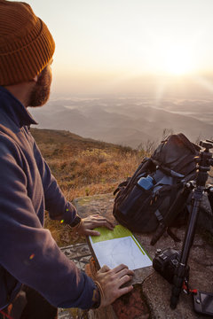 Man looking away while standing with map on observation point