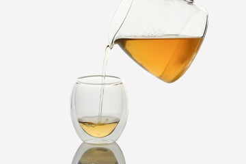 Tea pouring into Double-wall Glass Tea Cup, isolated in white