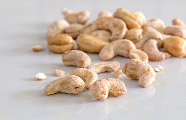 Cashew nuts coated with sugar and salt on tile background / Sele