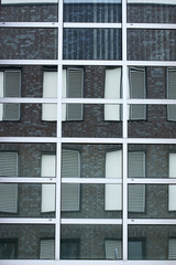 Gespiegelte Fenster / Die abstrakte Spiegelung von Fenstern mit Fensterläden in Spiegelfenstern.