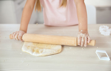 Obraz na płótnie Canvas Child with rolling pin and dough, closeup