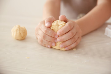 Little boy making biscuits on kitchen table