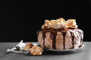 Cake with caramel and meringues on dark background