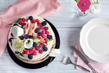 Delicious cake with fruit and berries decoration on white table