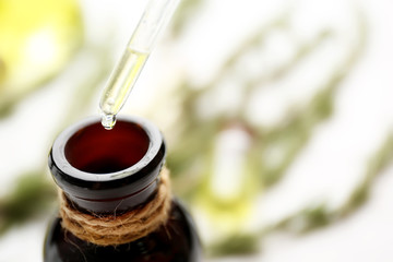 Obraz na płótnie Canvas Glass dropper and bottle of coniferous essential oil, close up view