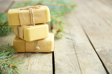 Pieces of coniferous soap and branches on wooden background, close up view