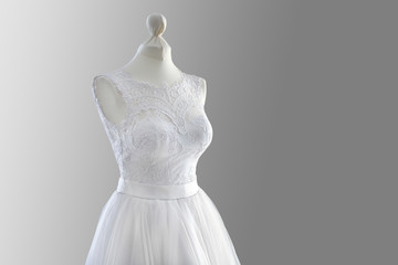 Fototapeta na wymiar Made-up wedding dress on mannequin against grey background
