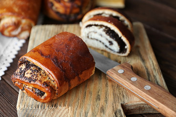 Tasty rolled bun on cutting board, closeup