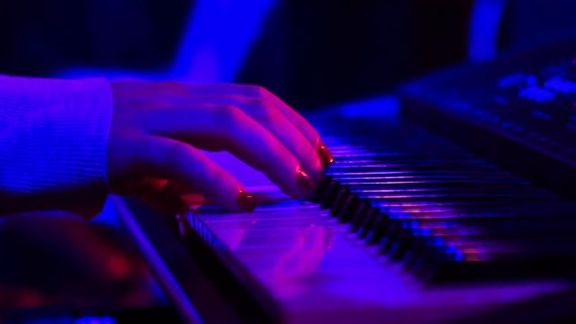 Girl Plays Electric Piano in Night Bar under Light Flashes